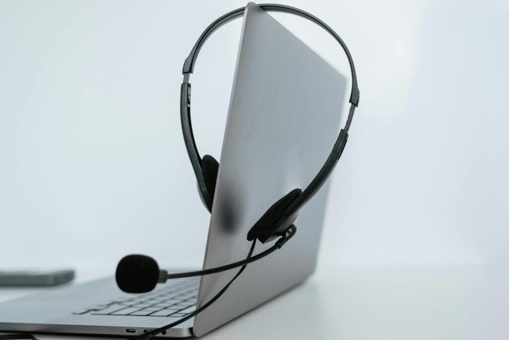 pexels-photo-7709095-7709095 Close-up of a laptop with a headset, symbolizing remote work or online communication.